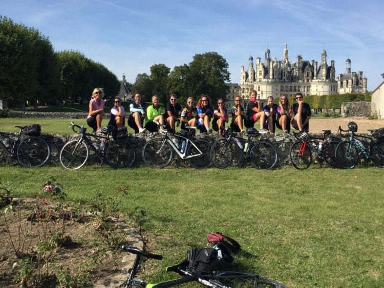 A group of cyclists poses in front of Chambord Castle