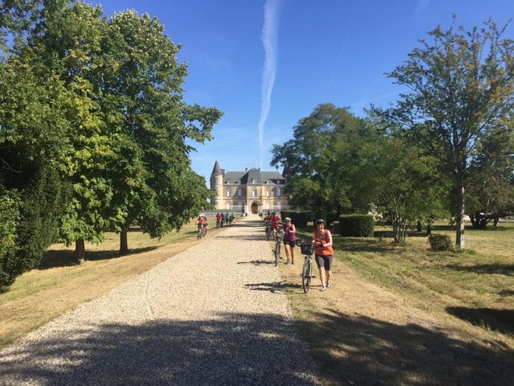 view of a biking group in front of a castle in Médoc