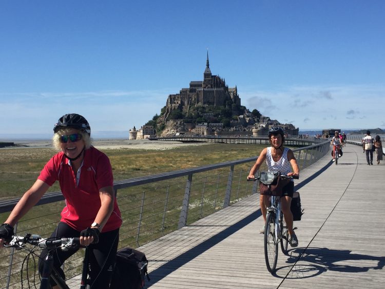 Radfahrer mit dem Mont Saint Michel im Hintergrund