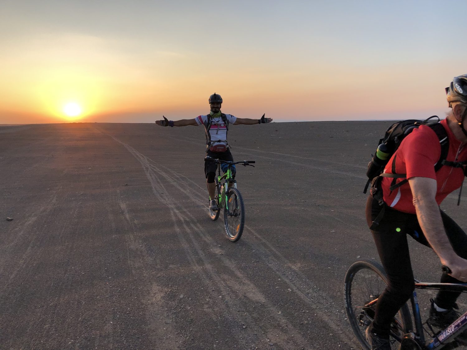 Blick auf Radfahrer in der Wüste Irans beim Sonnenuntergang